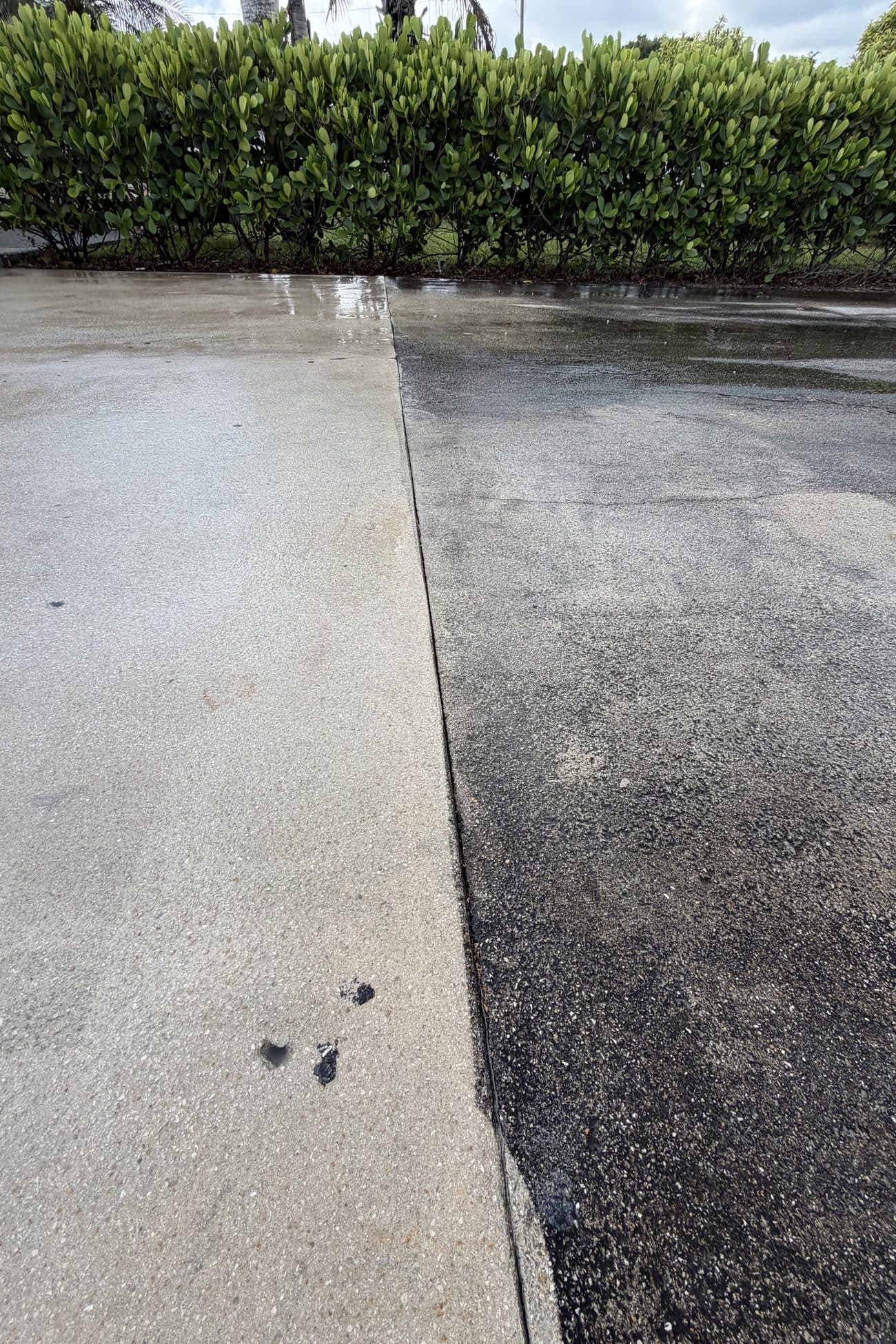 The hard edge left across a slab mid-clean — pale, cleaned concrete on one side, years of grey on the other